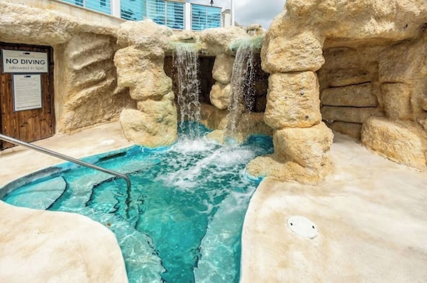 A hot spring with a pool, a no diving sign, and a wooden door.
