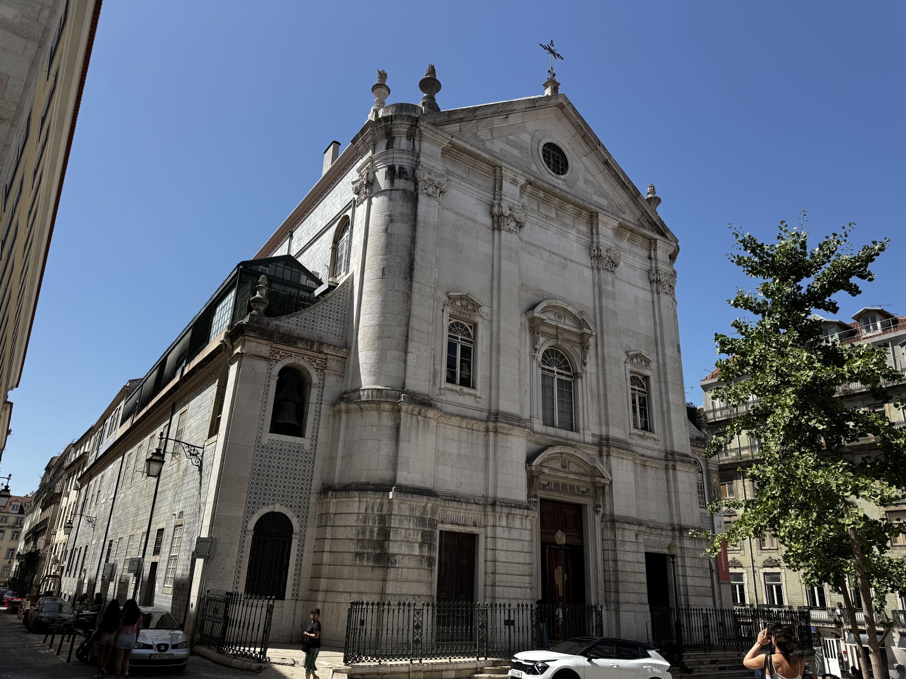 A historic building with a prominent entrance, large windows, and a bell tower.
