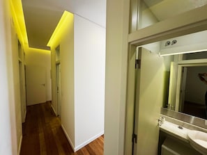 A hallway with wooden flooring, white walls, and a door at the end. - Lux Old Town (Lisboa)