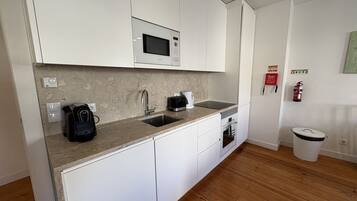 Deluxe appartement, uitzicht op stad | Gemeenschappelijke keuken | Een koelkast/vriezer, een magnetron, een oven, een kookplaat