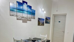 Un espace repas comprenant une table, des chaises et des œuvres d’art murales.