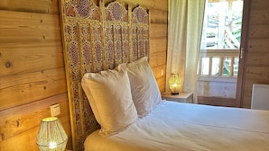 A wooden cabin-style bedroom with a bed, a nightstand with a lamp, and a window with curtains. - Luxury apartment, South-facing terrace, Exceptional view, Lock-up garage (Isola)