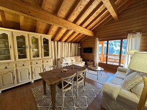 A wooden interior with a dining table, white sofa, and a cabinet. - Luxury apartment, South-facing terrace, Exceptional view, Lock-up garage (Isola)