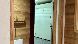 A hallway with wooden walls, a radiator, and a door leading to a room with a white door and a window. - Luxury apartment, South-facing terrace, Exceptional view, Lock-up garage (Isola)