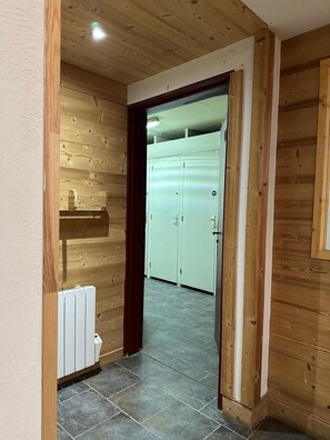 A hallway with wooden walls, a radiator, and a door leading to a room with a white door and a window. - Luxury apartment, South-facing terrace, Exceptional view, Lock-up garage (Isola)