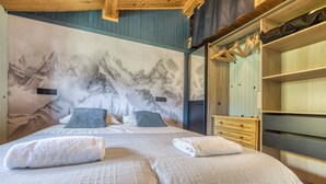 A bedroom with a mountain mural, a bed with two pillows, a wooden dresser, and a wardrobe. - Mazot des Outards - Swimming pool - Air conditioning - Cozy garden (Passy)
