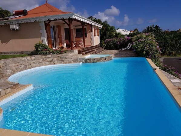 Une piscine avec une maison en arrière-plan.