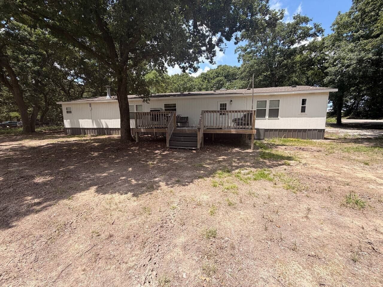 A single-story mobile home with a front porch and a small attached garage.
