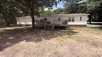 A single-story mobile home with a front porch and a small attached garage.