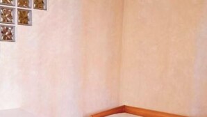 Een kleine kamer met een houten bed, een stoel en een tafel.