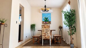 A spacious room with a dining area, a ceiling light, and a cactus painting. - Family home with private pool, loft and garage, super central location! (La Paz)