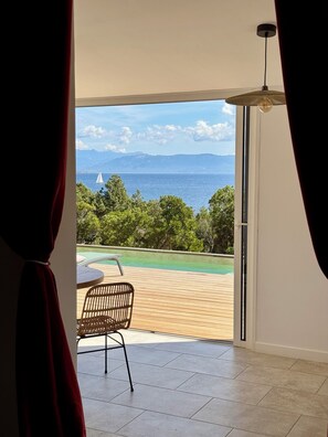 Ein Zimmer mit Blick auf einen Swimmingpool, einen Stuhl und einen Tisch.