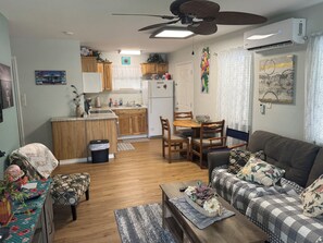 A living room with a sofa, coffee table, and a dining area with chairs and a table. - Emma's Casa Bonita; Cozy Coastal Cottage Near Rockport Attractions (Rockport)