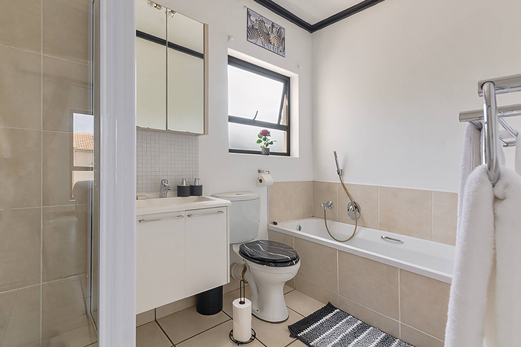 A bathroom with a toilet, sink, bathtub, and a shower.