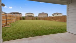 A backyard with a wooden fence, a lawn, and houses in the background. - 4-bedroom/3 bath house in brilliant Georgetown with cool AC. (Georgetown)