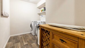 A laundry area with a washing machine, dryer, and wooden counter with a wine rack. - 4-bedroom/3 bath house in brilliant Georgetown with cool AC. (Georgetown)