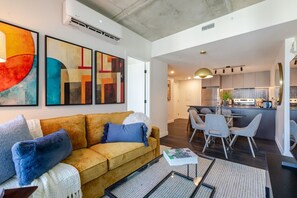 Ein modernes Wohnzimmer mit einer Couch, einem Couchtisch und abstrakter Kunst an der Wand.