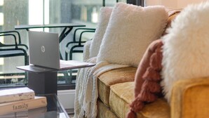 Uma sala de estar moderna com um sofá, um laptop e uma mesa.