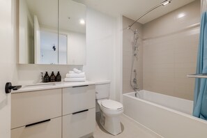 Un baño moderno con inodoro, lavamanos y ducha.