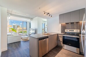 A modern kitchen with a dishwasher, oven, and built-in stove. - Chic Urban Retreat | Pool Gym & Terrace (Montreal)