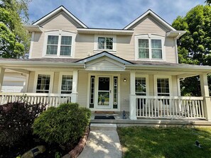 A two-story house with a front porch, a garage, and a well-maintained lawn. - Serene 4-bedroom and 2.5 bathroom house charming Rockford (Rockford)