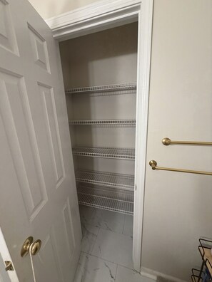 A narrow hallway with a white door, a white wall, and a metal rack with horizontal bars. - Serene 4-bedroom and 2.5 bathroom house charming Rockford (Rockford)