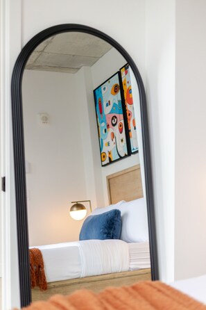 A bedroom with a bed, pillows, a bedside lamp, and a wall-mounted artwork. - Urban Prestige Apartment | Free Parking & Pool (Montréal)