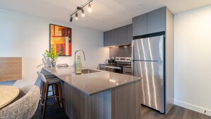 Een moderne keuken met een centraal eiland, roestvrijstalen apparatuur en een eigentijds design.