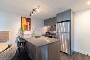 Eine moderne Küche mit einer zentralen Kochinsel, Edelstahlgeräten und einem zeitgemäßen Design.
