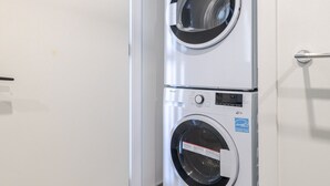 Une buanderie équipée de deux machines à laver à chargement frontal superposées.