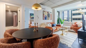 En moderne stue med et rundt bord, sofaer og et fjernsyn.