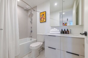 Ein modernes Badezimmer mit Dusche, Toilette und Waschtisch mit Spiegel.