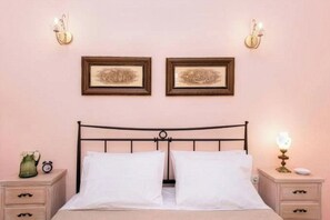 Ein Schlafzimmer mit einem Bett, zwei Nachttischen, einer Ablage und Wandlampen.