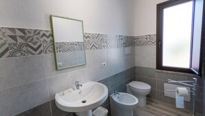 A modern bathroom with a pedestal sink, a bidet, and a toilet. - Lovely guesthouse 10 minutes from the beautiful beaches of the Gulf of Orosei (Irgoli)