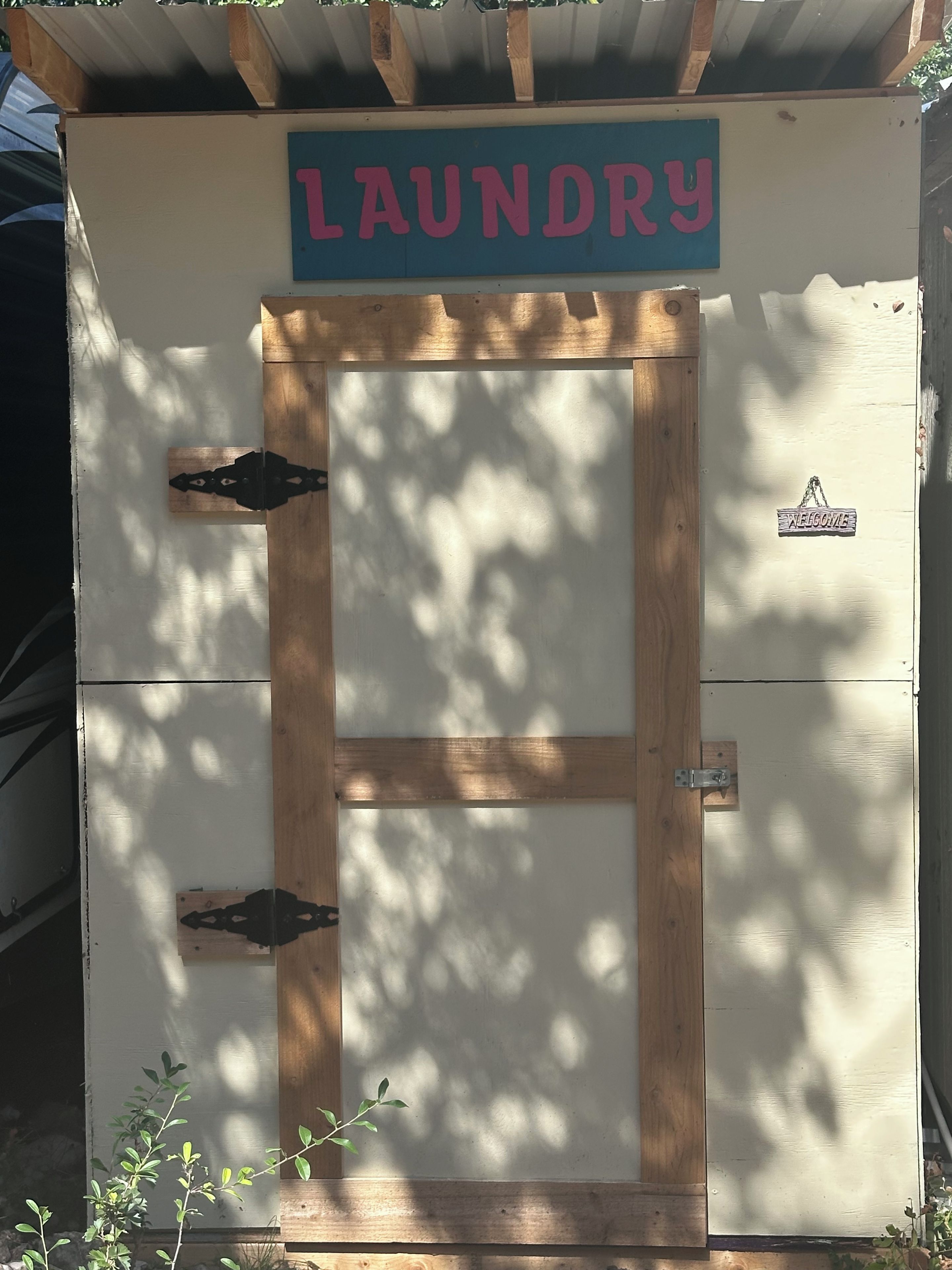 Une laverie avec une porte en bois et une enseigne au-dessus.