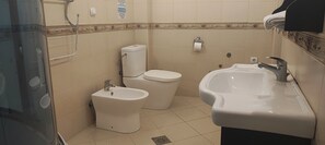 Ein Badezimmer mit einer Bidet, Toilette und Waschbecken.
