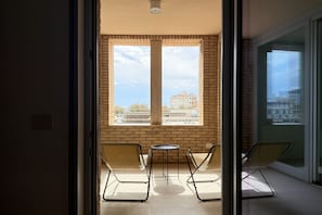 Ein Balkon mit Blick auf Gebäude, einem Tisch und Stühlen.