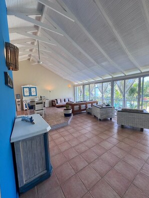 A spacious indoor area with a high ceiling, large windows, and a variety of seating arrangements. - Spacious 3-bedroom condo in adorable Las Terrenas with AC (Las Terrenas)