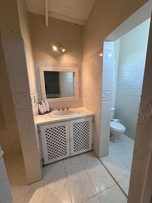 A bathroom with a white vanity, a mirror, a sink, and a toilet. - Spacious 3-bedroom condo in adorable Las Terrenas with AC (Las Terrenas)