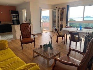 A living room with a sofa, chairs, a coffee table, a dining table, and a view of the outdoors. - Family apartment with sea view 500m from the sea (Albitreccia)
