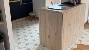 Een compacte keuken met een centraal eiland, een magnetron en een oven.