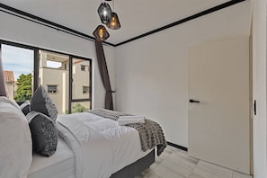 Ein Schlafzimmer mit einem Bett, einem Fenster und einer Tür.