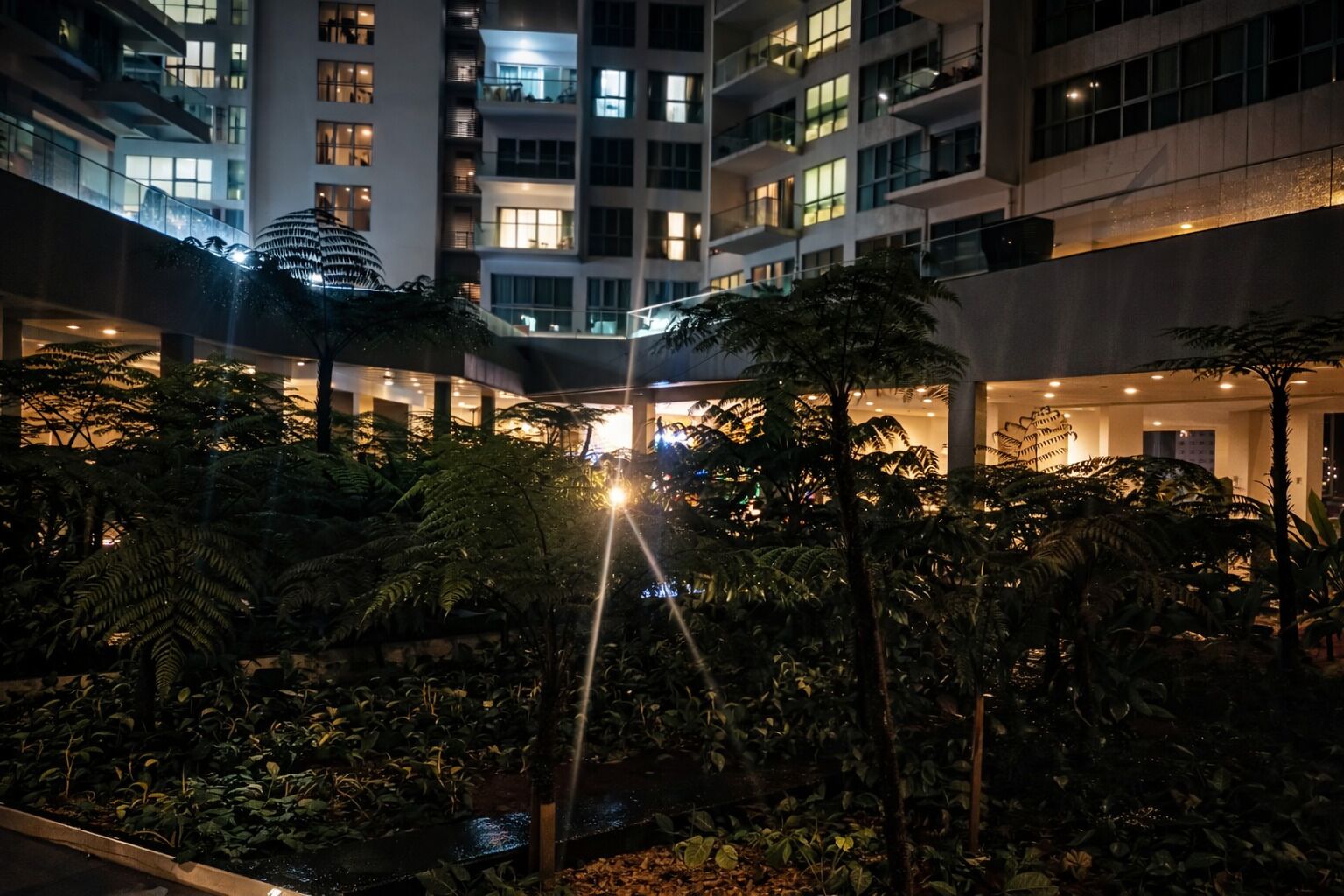 A multi-story building with a central atrium, surrounded by dense tropical foliage.