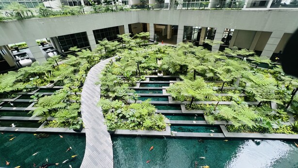 A multi-level indoor garden with water features and a central pool. - Regalia Sky Pool KLCC Luxury KL by SS (Kuala Lumpur)