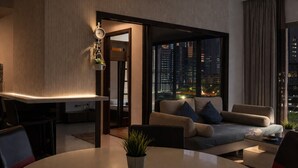 A modern living room with a sofa, a dining table, and a city view through large windows. - Regalia Sky Pool KLCC Luxury KL by SS (Kuala Lumpur)