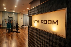 A gym room with a sign, wooden flooring, and exercise equipment. - Regalia Sky Pool KLCC Luxury KL by SS (Kuala Lumpur)