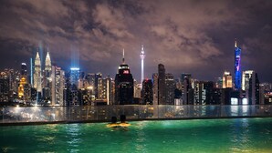 A nighttime cityscape with a pool and a view of the skyline. - Regalia Sky Pool KLCC Luxury KL by SS (Kuala Lumpur)