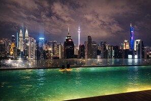 A nighttime cityscape with a pool and a view of the skyline. - Regalia Sky Pool KLCC Luxury KL by SS (Kuala Lumpur)