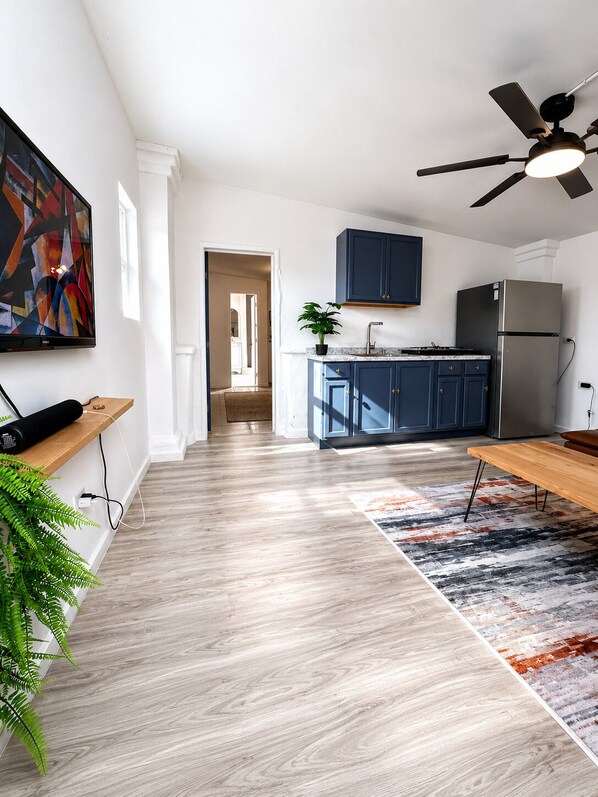 A modern kitchen with a built-in stove, a refrigerator, and a ceiling fan.