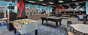 Ein Gaming-Center mit Tischfußball, Billardtischen und Gaming-Stationen.